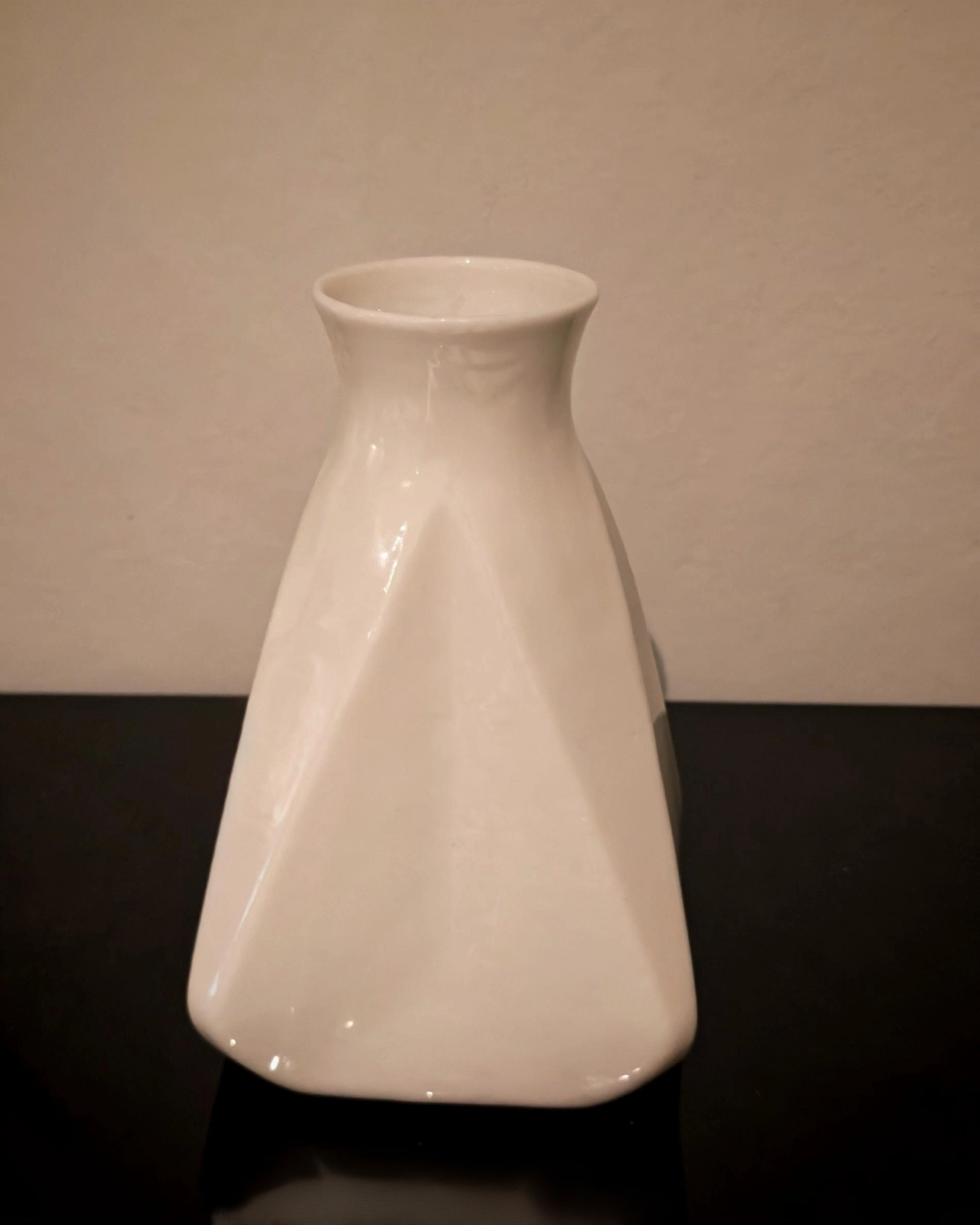 Vase triangulaire blanc seul montrant la finition brillante effet céramique